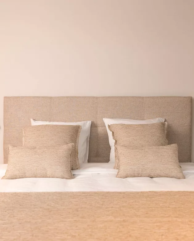 De Slaapkamer met bed, bedlinnen en raamdecoratie 